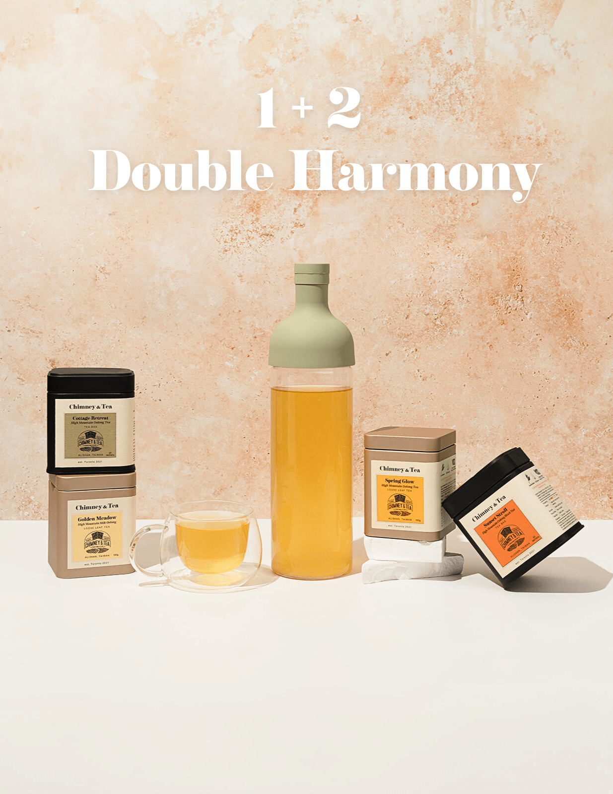 Bottle of tea, cup, and tea boxes on a light background with '1 + 2 Double Harmony' text.